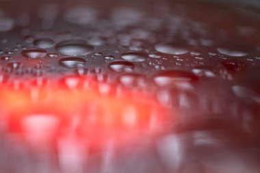 Islak, parlak, soyut bir arkaplan. Gri, turuncu renkler.