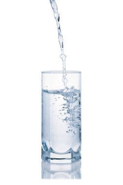 Temiz su beyaz zemin üzerinde izole edilmiş bardağa dökülüyor.