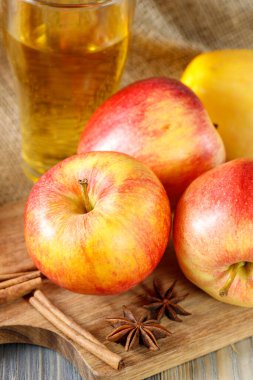 Taze kırmızı elmalar ve bir bardak elma şarabı ya da ahşap masa üzerindeki köpüklü meyve suyu. Şükran Günü kartı