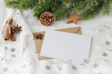 Noel tebrik kartı modeli köknar dalı, beyaz keten tekstil arka planında boş kağıt ve dekor..