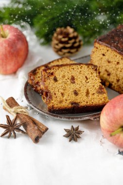 Beyaz keten masa örtüsünde seramik tabakta elmalı ve tarçınlı ev yapımı kek dilimleri.