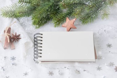 Köknar dalıyla eski yılbaşı tebrik kartı modeli, beyaz keten tekstil arka planında boş defter ve dekorasyon kağıdı.