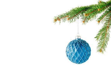 Köknar ağacının dalında asılı duran mavi Noel cam küresi beyaz arka planda izole edilmiş. Kopyalama alanı olan şenlikli çerçeve