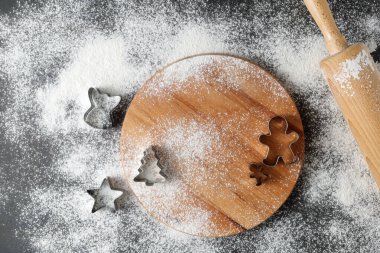 Şenlikli mutfak un arka planı kesicili zencefilli kurabiye yapmak için, ahşap raptiye ve vintage masa üzerinde tahta merdane. Kopyalama alanı olan üst görünüm kartı.