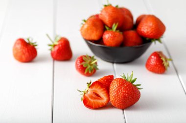 Taze olgun çilekler beyaz ahşap arka planda çilekler.