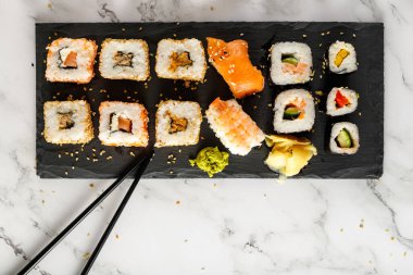 Çubuklu ve soya soslu lezzetli suşi. Taş tahtada. Kopyalama alanı olan mermer arkaplan