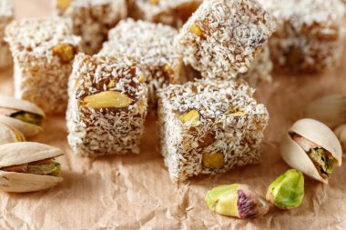 Fıstıklı ve hindistancevizli küp Türk Lokumu. Kağıt arka planda yakın plan. Geleneksel doğulu tatlıları rahat lokum