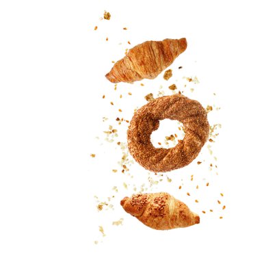 Türk simit simülasyonu, Fransız tereyağı ve badem fıstıklı kruvasanlar beyaz arka planda izole edilmiş kırıntılarla uçuyor.. 
