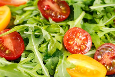 Çeri domatesli, zeytinyağlı ve baharatlı vejetaryen taze roka salatası. Üst görünüm 