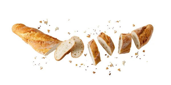 新鮮な焼きたてのローフ小麦のバゲットのパンを切り取り 白の背景に孤立して飛んでいるパン粉と種子 — ストック写真