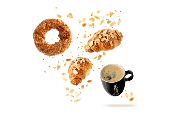 Fresh baked turkish simit sesame bagel, french butter almond nut croissants and black cup hot coffee flying with seeds and crumbs isolated on white background. Pastry shop card