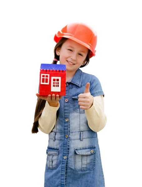 Menina bonita com a casa de brinquedo em um capacete laranja — Fotografia de Stock