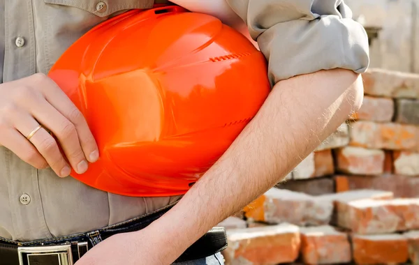 L'uomo tiene in mano un casco protettivo da costruzione — Foto Stock
