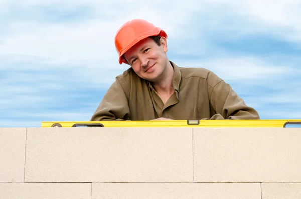 Costruttore con un cappello duro contro il cielo — Foto Stock