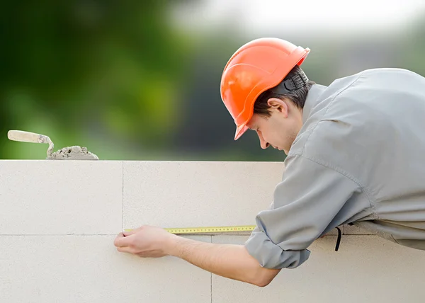Construtor ergue uma parede — Fotografia de Stock
