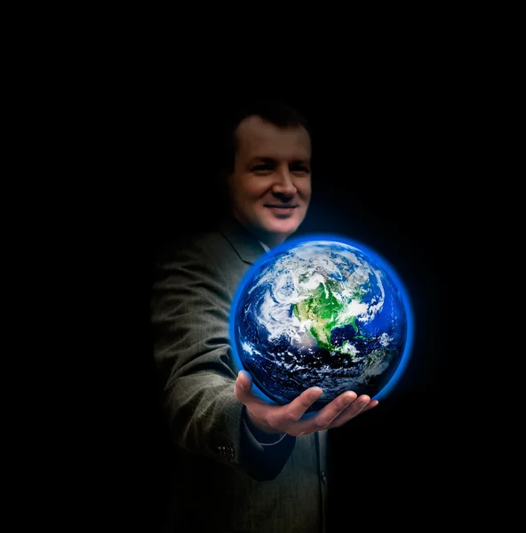 Ung affärsman höll i handen ett glödande jorden världen — Stockfoto