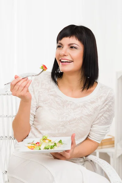 Mujer sonriente comiendo ensalada de verduras frescas — Foto de Stock