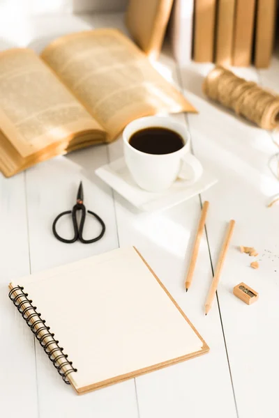 Notepad, coffee and books on wooden table — Stock Photo, Image