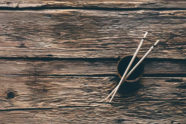 Ätpinnar och skål med sojasås på woodend bord — Stockfoto