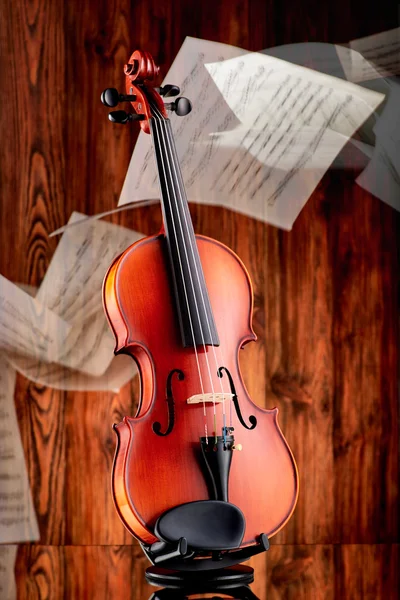 Close-up de um violino na superfície de vidro e fundo de madeira — Fotografia de Stock