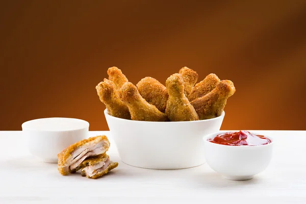 Kippenvleugels en sauzen op de tafel — Stockfoto