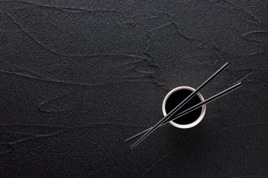 Yemek çubukları ve kase soya sosu siyah kaya ile