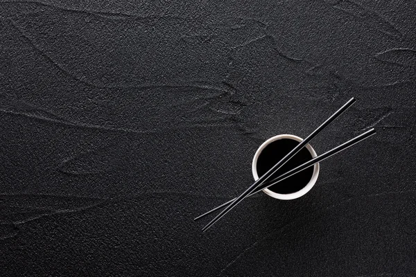 Yemek çubukları ve kase soya sosu siyah kaya ile