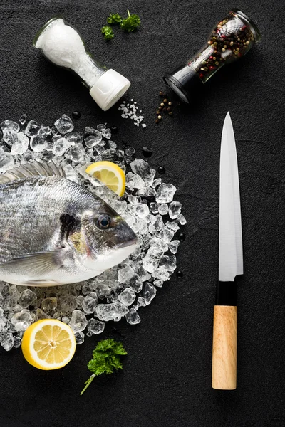 Čerstvé ryby dorado na ledu na černý kámen stolu zobrazení — Stock fotografie