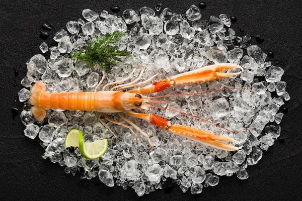 Čerstvé krevety krevety na ledu na černý kámen stolu zobrazení — Stock fotografie