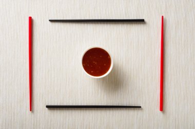 Üstten Görünüm mat chopsticks ve kase masada sos ile