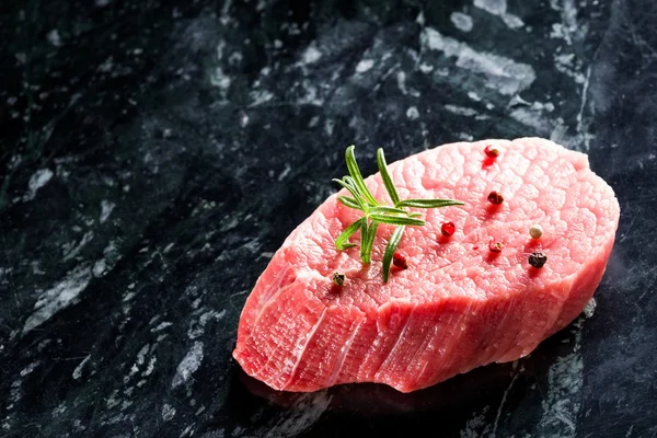 Filete de res fresco crudo sobre fondo de mármol oscuro de cerca — Foto de Stock