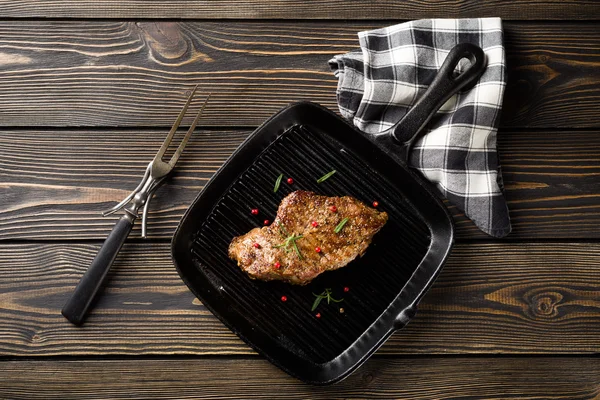 Hovězí steak na gril pánev na dřevěný stůl horní pohled — Stock fotografie