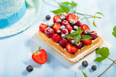 Waffle çilek ve böğürtlen meyve mavi masada