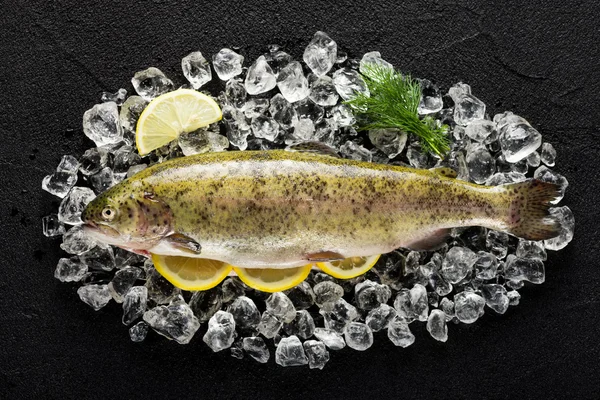 Alabalık balık ve malzemelerin üzerine siyah taş masa üstü buza vie
