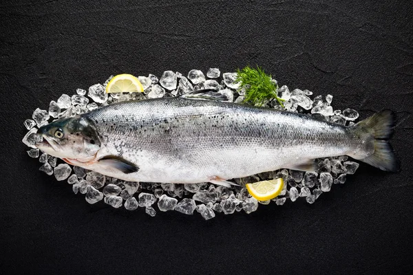 Saumon poisson et ingrédients sur glace sur un plateau en pierre noire vi Image En Vente