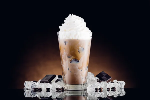 冰咖啡在玻璃和碎的冰上棕色背景 图库图片