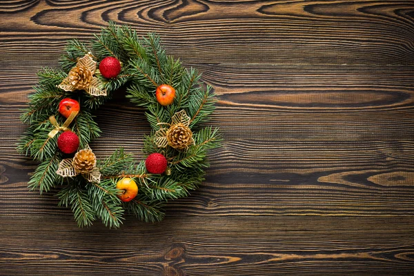 Corona de Navidad sobre tabla de madera marrón vista superior — Foto de Stock