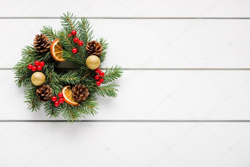 Christmas wreath on white wooden table top view