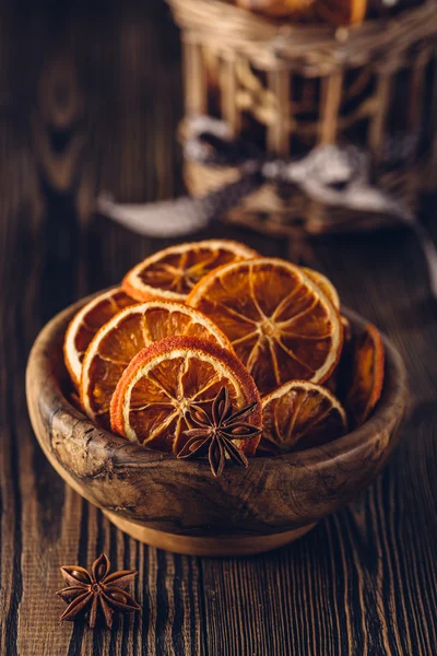 Anise and dried oranges in bowl on a wooden table. Shallow dof. — Stock Photo, Image