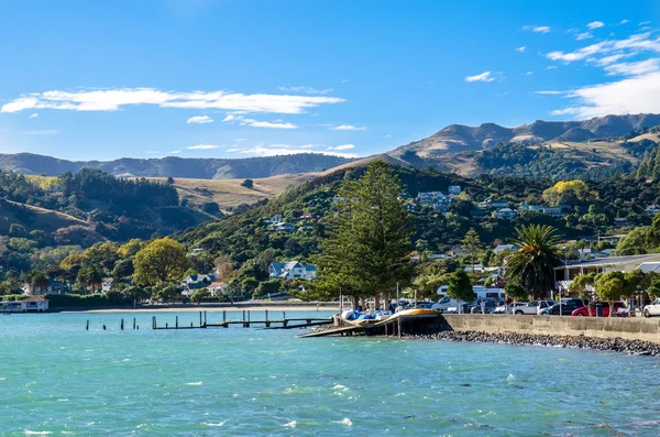 Jetty pier of Akaroa, south island of New Zealand. People can seen exploring around it. — Stock Photo, Image