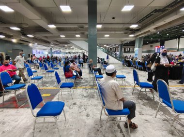 Selangor, Malezya - 6 Temmuz 2021: MIECC Seri Kembangan 'daki Sinovac aşısı sonrasında salonda sabırla bekleyenler görülüyor.