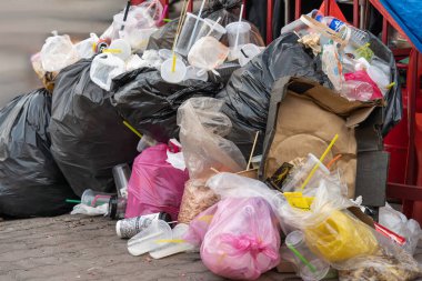 Selangor, Malezya - 19 Ekim 2025: Çöp, çöp ve kentsel kirliliği vurgulayan bir sokak sahnesinde taşan çöp torbaları