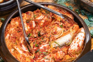 Geleneksel Kore Napa lahana kimchi 'si, acı biber, sarımsak, zencefil ve balık sosuyla yapılır, zengin baharatlı ve keskin bir tat geliştirmek için mayalanır, klasik bir Kore mezesi olarak servis edilir..