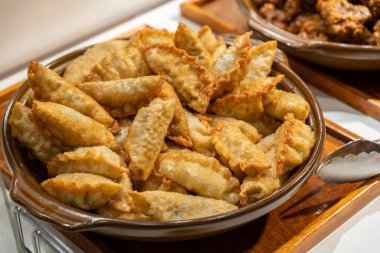 Kızarmış altın hamur köfteleri, lezzetli bir aperatif ya da aperatif olarak sunulan kırsal seramik bir yemeği doldurur..