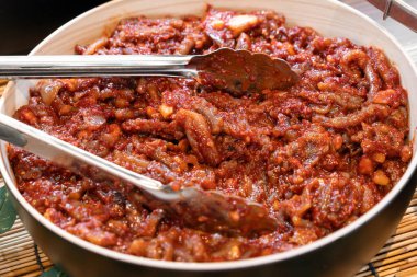 Baharatlı baharatlı mayalanmış bebek ahtapot. Cesur, tuzlu ve umami kadar zengin..