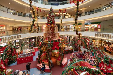 KL, Malaysia-Dec 2, 2025:Mid Valley Megamall atrium transformed for Christmas, featuring a towering central tree, colorful lights, garlands, and gift-filled displays. People can seen exploring around.