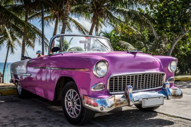 Varadero, Küba - 22 Haziran 2015: Küba'da denize yakın pembe klasik araba park