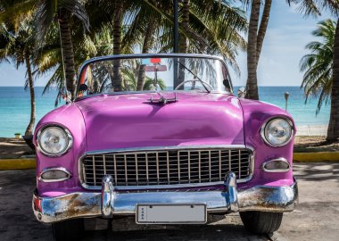 Varadero, Küba - 22 Haziran 2015: Avuç içi altında plaja yakın pembe Amerikan cabriolet eski model araba park