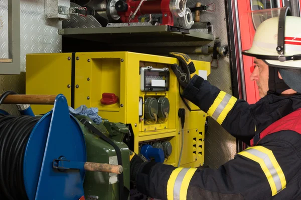 Bombero en acción y utiliza el generador de electricidad —  Fotos de Stock