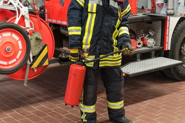 Firefighter in action with a fire extinguisher — Stock Photo, Image